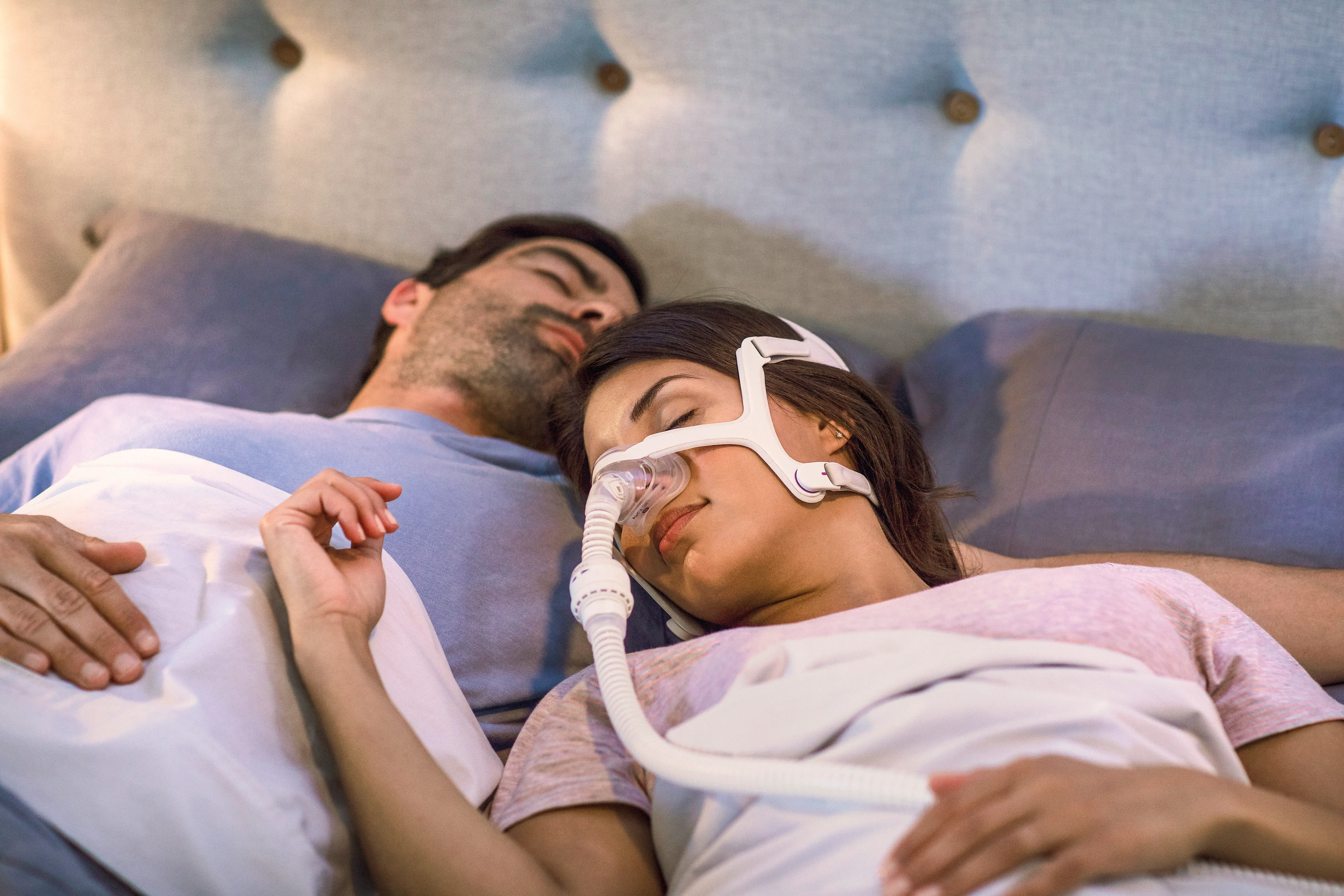 Man and woman sleeping with CPAP Mask